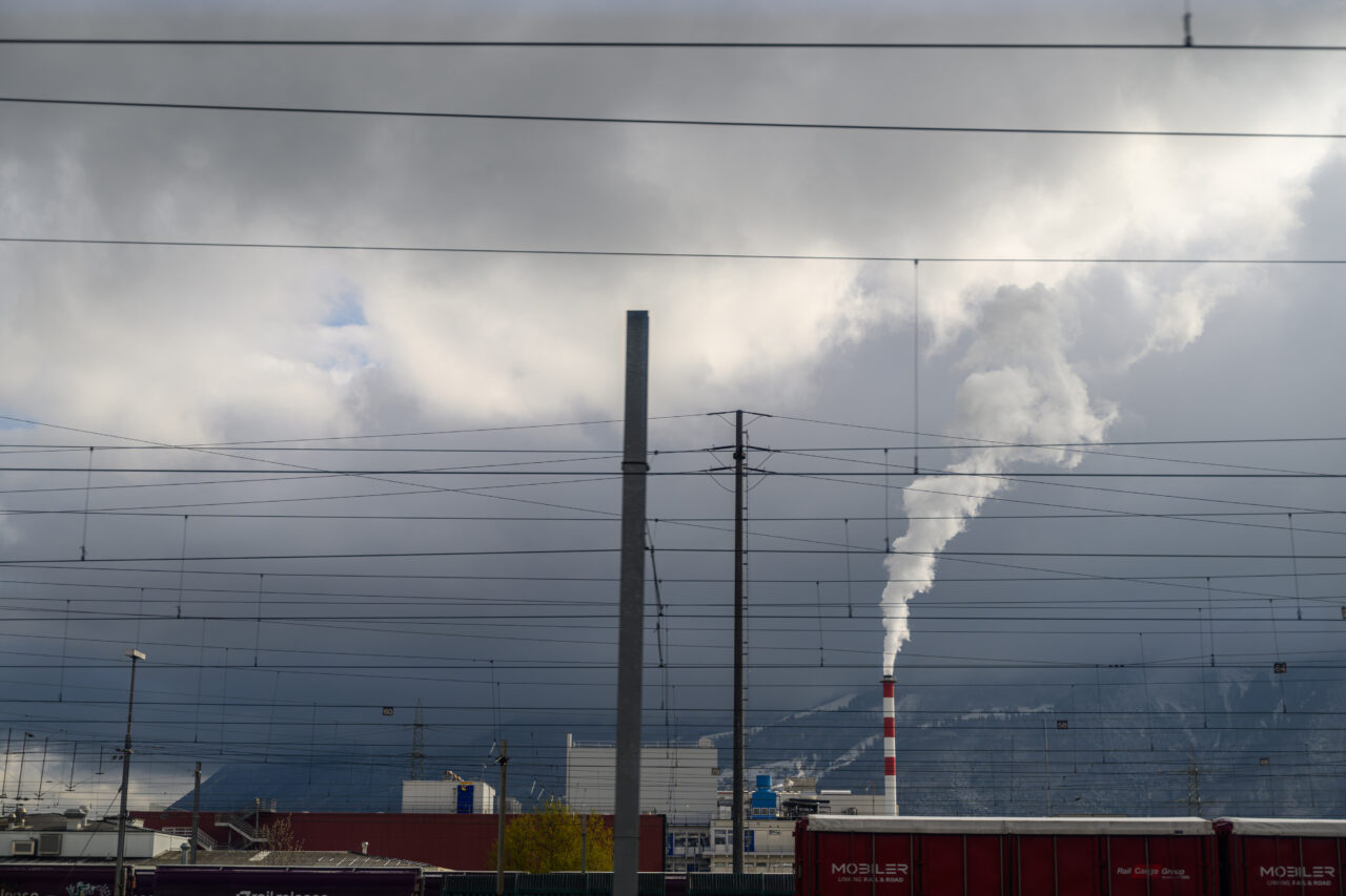 Rauchender Schornstein unter bewölktem Himmel