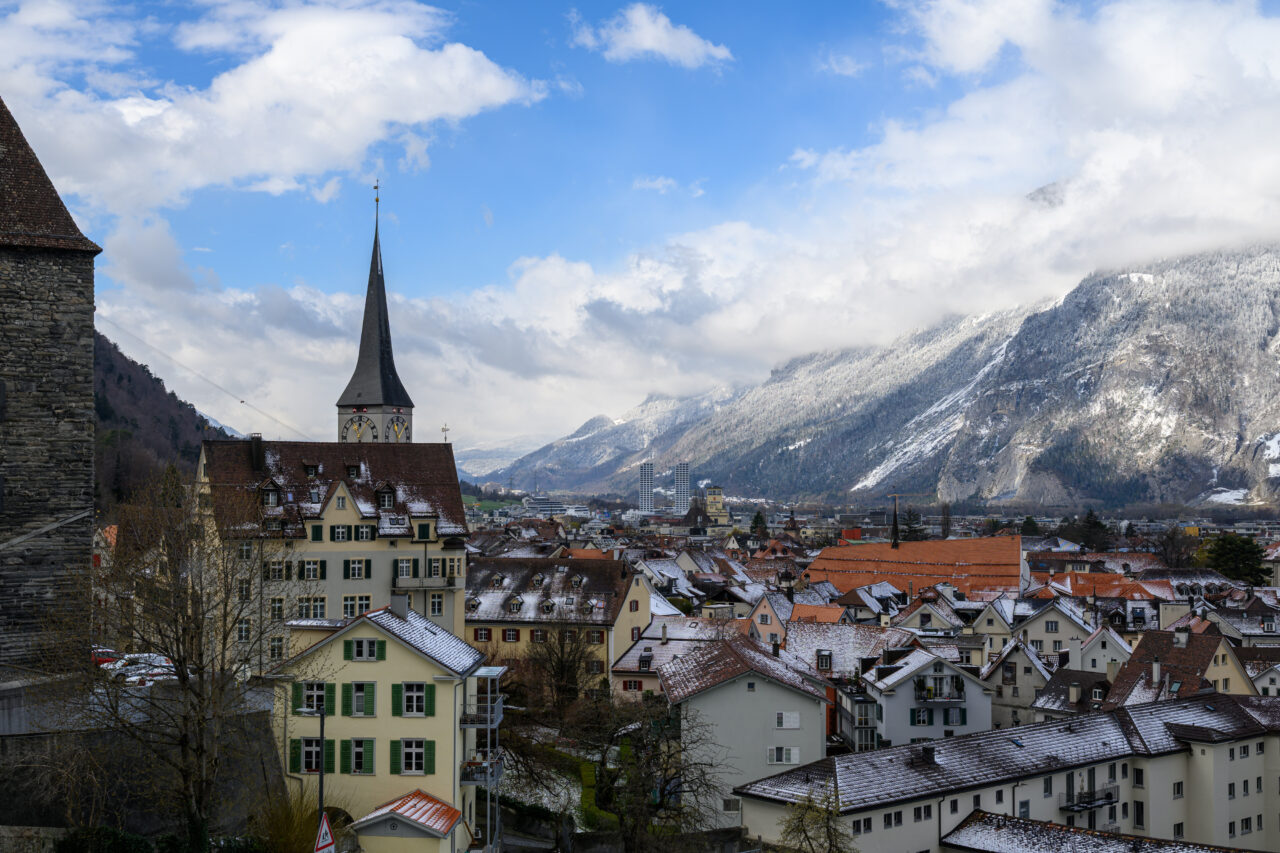 Schneebedeckte Stadt mit Bergen im Hintergrund