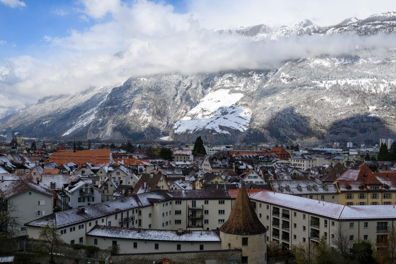 Schneebedeckte Stadt mit Bergen im Hintergrund