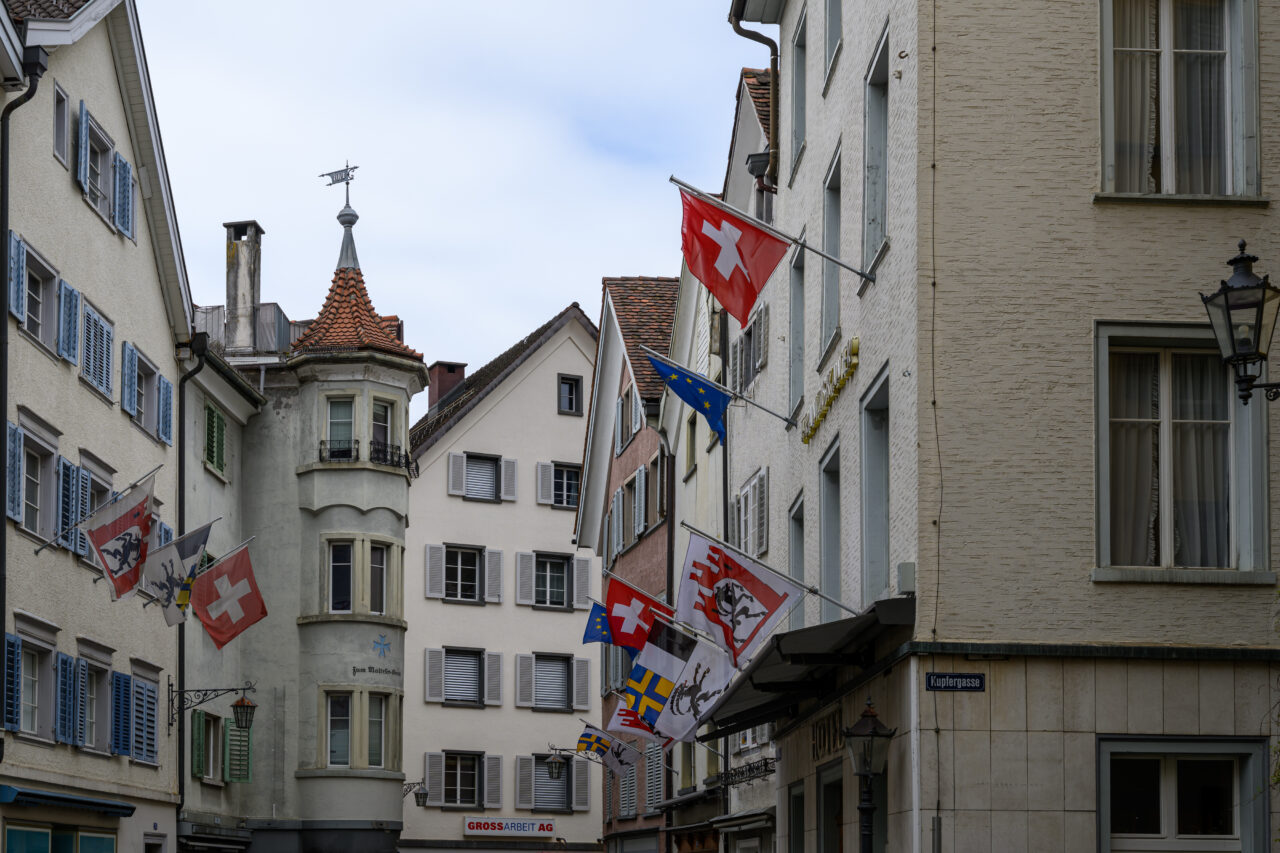 Schmalstraße mit Fahnen und historischen Gebäuden