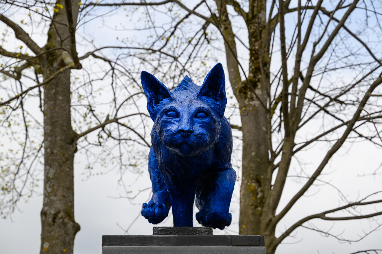 Blaue Fuchsstatue vor Bäumen