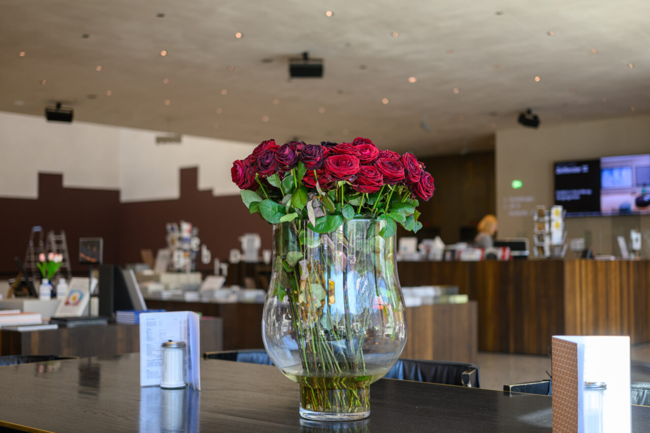 Vase mit roten Rosen in einem Café